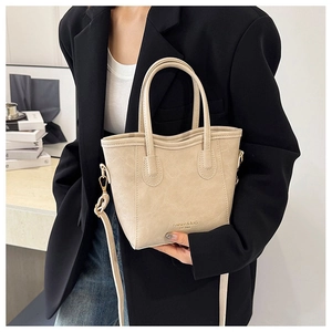 Detalle del bolso de cuero beige con texto Fashion & Bag y correa de hombro ajustable