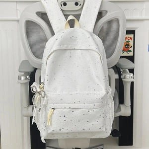 Détail du sac à dos blanc à imprimé étoiles avec nœud en dentelle et pendentif perle
