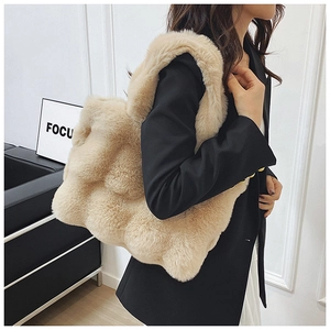 Detail of beige plush tote bag showing textured faux fur square pattern and soft material