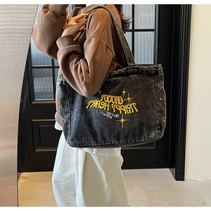 Détail de la broderie pop art jaune sur un sac cabas en toile délavée