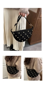 Detail of black suede crescent bag with gold studs and adjustable shoulder strap
