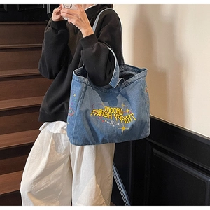 Détail du grand sac cabas en denim bleu délavé avec broderie Groovy Trippy Heart jaune