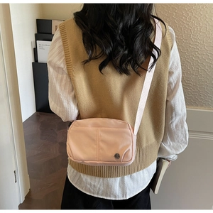Vue arrière d'une femme portant un mini sac bandoulière en nylon rose ajustable