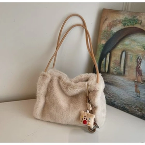 Dettaglio borsa shopper in ecopelliccia crema con spalline in pelle e ciondolo a orso
