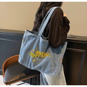 Détail du sac cabas en denim bleu avec broderie jaune Groovy Trippy Heart et motif étoiles