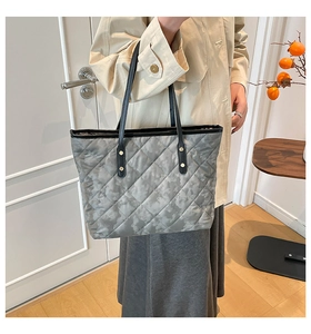 Détail du sac cabas gris matelassé avec motif camouflage et rivets dorés élégants