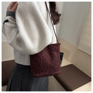 Detalle de bolso saco con estampado de leopardo rojo oscuro y textura de ante suave