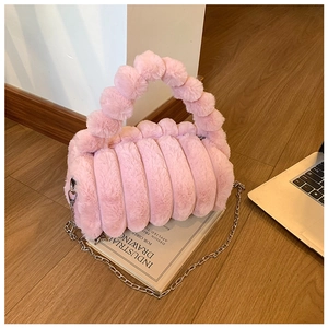 Détail d'un sac à main en fausse fourrure rose avec texture matelassée et anse