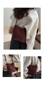 Detalle de bolso leopardo rojo con colgante de oso de peluche y correas de cuero