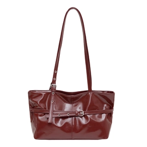 Polished burgundy patent leather shoulder tote bag with adjustable straps and buckle detail