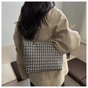 Detail van het getextureerde tweed houndstooth weefsel en de metalen ketting van de schoudertas