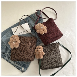 Tres bolsos de leopardo en marrón, rojo y gris con dijes de osito de peluche