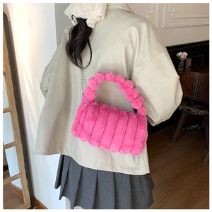 Détail du sac à main en peluche rose fuchsia avec poignées sphériques et chaîne dorée