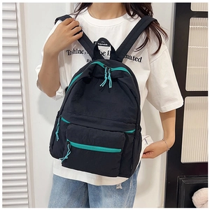 Dettaglio dello zaino casual nero con zip blu indossato da una modella per la taglia