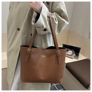 Close-up of the vintage brown tote bag with gold brand logo and adjustable strap