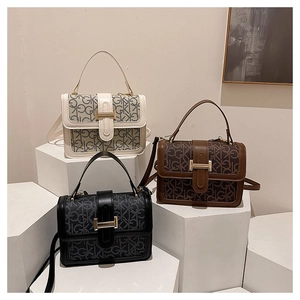 Detail view of structured crossbody bags in white, brown, and black with logo pattern