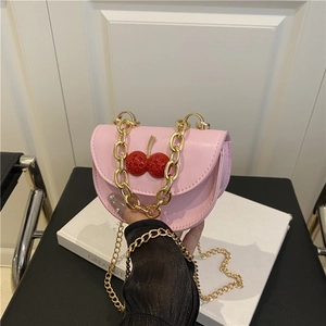 Mini bolso bandolera rosa con detalle de cereza y cadena dorada sujeto a mano