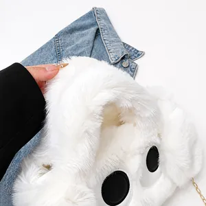 Close-up of white plush crossbody bag with cute eye design and golden metal chain