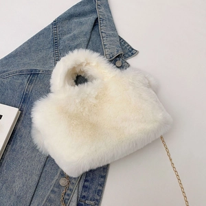 Détail du sac à main en fausse fourrure blanche avec texture peluche et chaîne dorée
