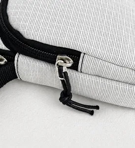 Close-up of smooth metal zipper and textured gray fabric on casual shoulder bag
