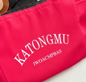 Close-up of rose red nylon bag detail featuring white KATONGMU letter print