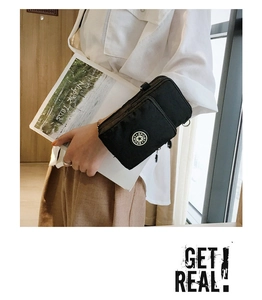 Detail of black sports arm bag with multiple zipper compartments and star logo