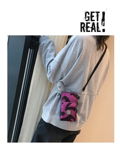 Detail of a purple camouflage mini crossbody phone bag with zipper and adjustable strap