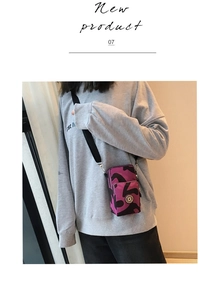 Close-up of a mini crossbody phone bag with purple camo print and SPORT logo