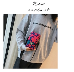 Detailed view of floral crossbody phone bag with adjustable strap and sport logo