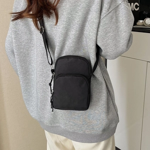 Minimalist black nylon crossbody phone bag with adjustable strap and double zip layers