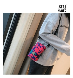 Detail view of mini nylon crossbody phone bag with vibrant rose red abstract pattern