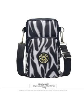 Detail showing zebra print nylon fabric and sport logo on a crossbody phone bag