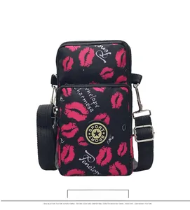 Detail view of mini crossbody phone bag with pink lip prints and double zipper storage
