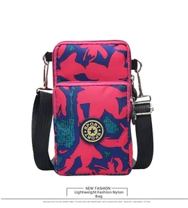 Detail view of pink graffiti nylon crossbody phone bag with durable dual-layer zippers
