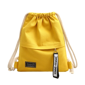 Bright yellow canvas drawstring backpack with white rope straps and front zipper pocket