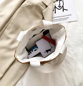 Top view of the spacious inner compartment of this chic straw-trimmed summer tote bag