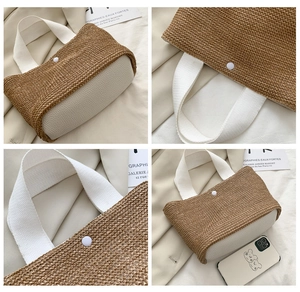 Detail view of woven straw handbag featuring white leather base and magnetic closure