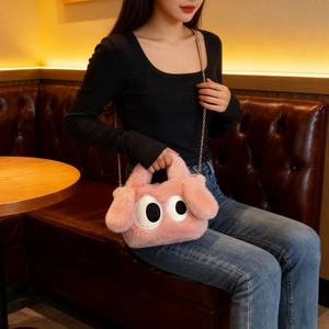 Vue détaillée du sac en peluche rose avec yeux de dessin animé et chaîne dorée