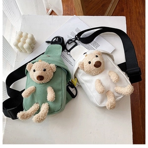 Detail view of mini canvas crossbody bags with 3D plush bears in green and white