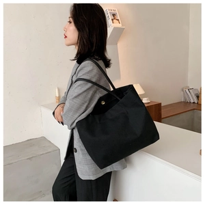 Détail du grand sac cabas en toile noire avec boucle magnétique et intérieur spacieux