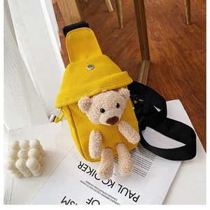 Close-up of yellow canvas chest bag featuring a 3D plush bear and adjustable strap