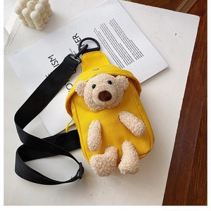 Detail of yellow canvas bag with 3D plush teddy bear and adjustable black strap