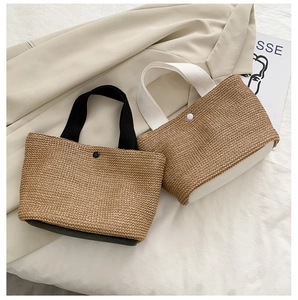 Detail shot of straw woven beach tote showing the snap closure and woven texture