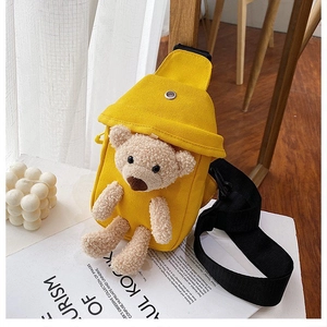 Detail of yellow canvas crossbody bag featuring a 3D plush bear and adjustable strap