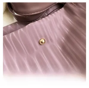 Detail of lavender pleated texture bag with elegant gold metal decorative buckle