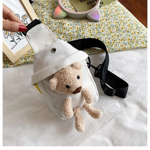 Detalle del bolso de pecho de lona blanca con osito de peluche 3D y correa ajustable