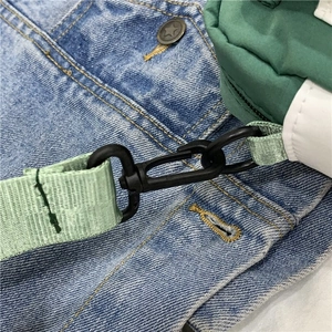 Détail du sac en toile verte avec boucle en plastique et bandoulière en nylon robuste