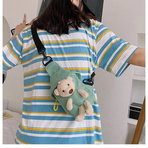 Detail of cute mint green canvas chest bag featuring a 3D plush teddy bear mascot