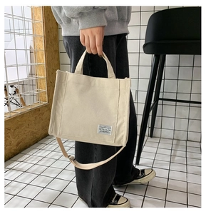 Dettaglio della borsa tote in velluto a coste bianco crema con toppa e doppi manici