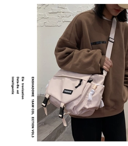 Detail of beige nylon messenger bag featuring black buckles and fashion logo label